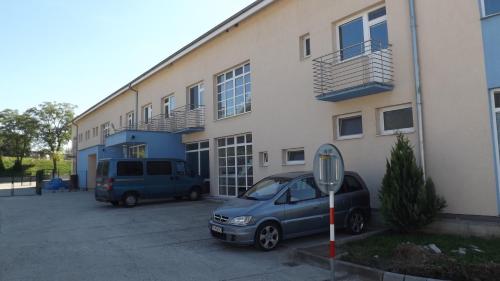 two cars parked in a parking lot in front of a building at Penzión Lindava in Budmerice