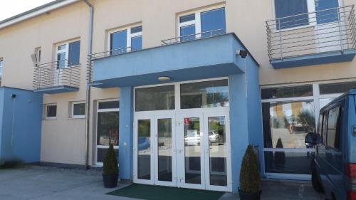 a blue and white building with glass doors at Penzión Lindava in Budmerice