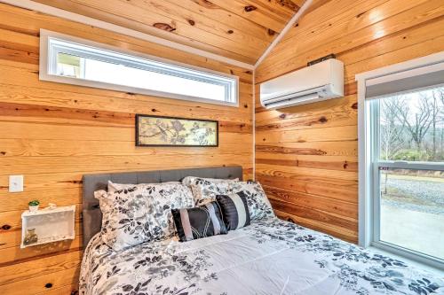 a bedroom in a tiny house with a bed and a window at Newly Built Morganton Tiny Home with Deck! in Morganton