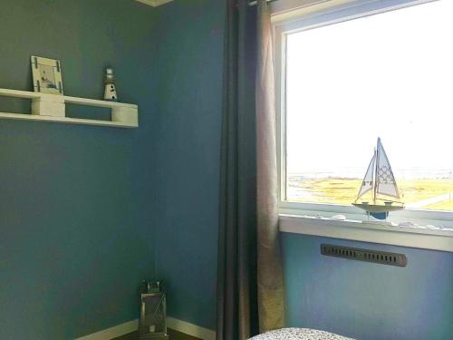 uma casa de banho com uma parede azul e uma janela em Holiday home Leinøy em Fosnavåg