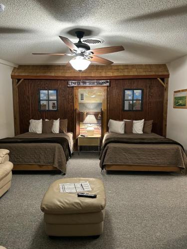 a bedroom with two beds and a ceiling fan at Country Cabins Hotel in Chariton