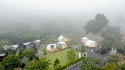 an aerial view of a house in the fog at Heaven Hill Camping in Ban Thung Na