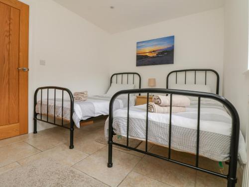 two twin beds in a room with a door at An Garth in Penzance