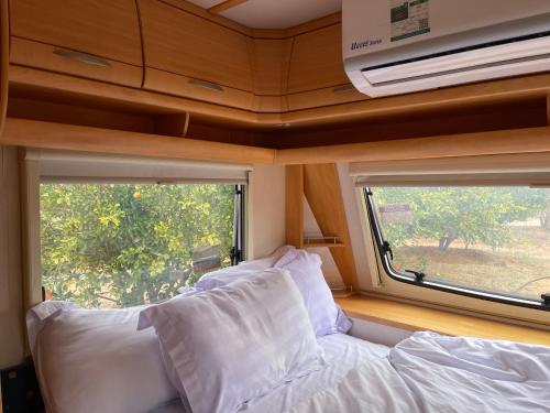 a bedroom with a couch and a window in a caravan at Naseem Country House in AlUla