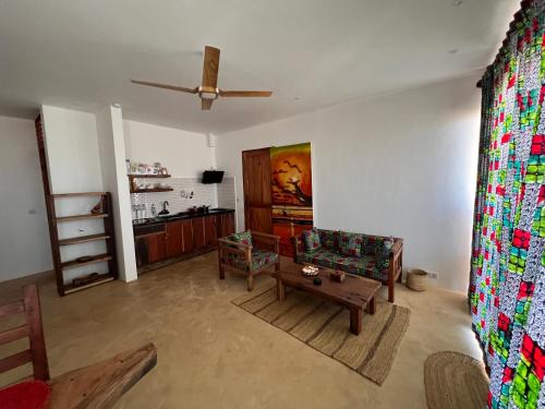 a living room with a ceiling fan and a couch at The View of Zanzibar in Michamvi