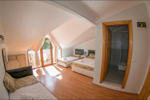 a living room with two beds and a mirror at Boncuklu Otel in Fethiye