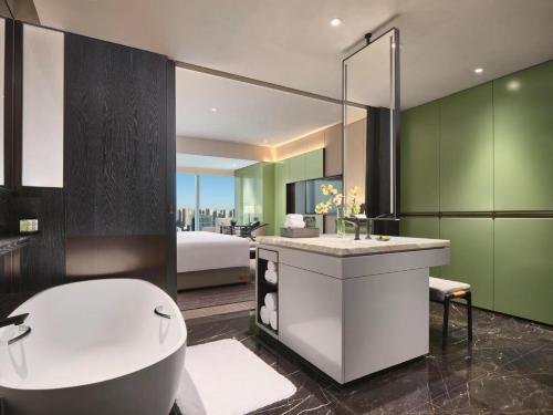 ein Bad mit einer Badewanne und ein Schlafzimmer in der Unterkunft InterContinental Xi'an North, an IHG Hotel in Xi'an
