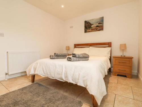 a bedroom with a large bed and a night stand at An Gwel in Penzance