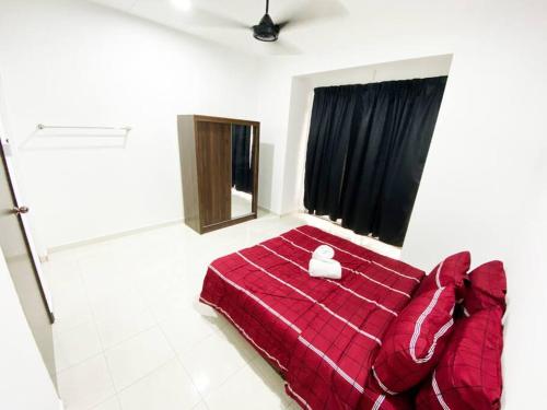1 dormitorio con cama roja y manta roja en D'Cahaya Homestay Batu Pahat, en Batu Pahat