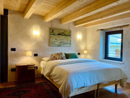 um quarto com uma cama grande e uma janela em Le Camere di Marietta em Rovere Veronese