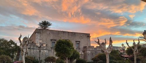 un viejo edificio con un árbol encima en Da mare e d'amore, en Spadafora