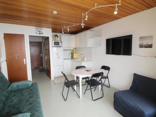 un salon avec une table, des chaises et un canapé dans l'établissement Studio Cabine Rénové au Pied des Pistes avec Balcon - Auris en Oisans - FR-1-297-157, à Auris