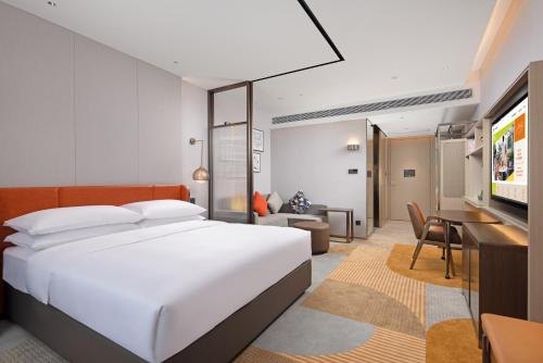 1 dormitorio con 1 cama grande y sala de estar en Home2 Suites By Hilton Shenzhen Dalang, en Shenzhen