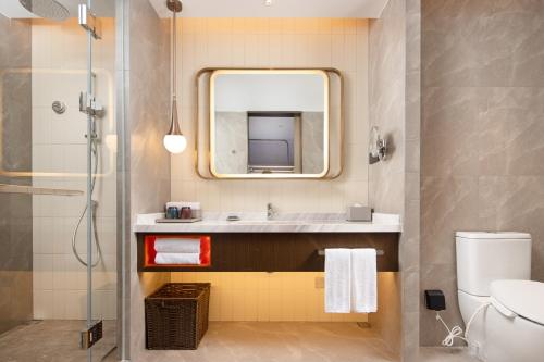bagno con lavandino, specchio e servizi igienici di Home2 Suites By Hilton Shenzhen Dalang a Shenzhen