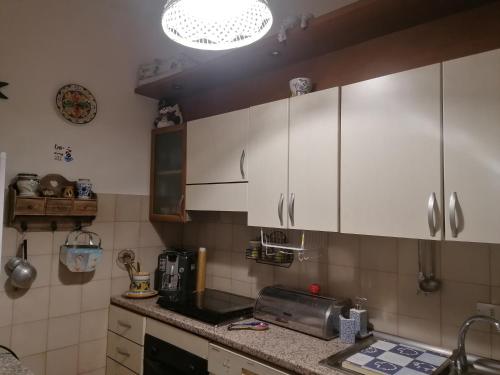 cocina con armarios blancos y encimera en Da mare e d'amore, en Spadafora