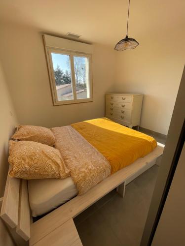 - une chambre avec un lit, une commode et une fenêtre dans l'établissement Chez Jo’, à Vézénobres