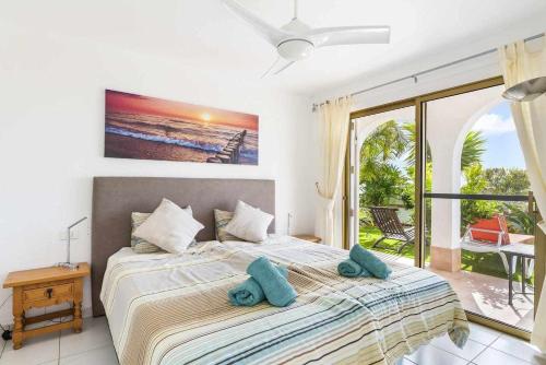 um quarto com uma cama com toalhas azuis em Family Chayofa by W Tenerife em Chayofa