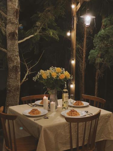 a table with plates of food and candles on it at Oak Village by D Home Da Lat in Da Lat