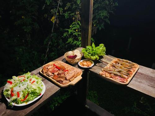 a picnic table with two trays of food and salads at Oak Village by D Home Da Lat in Da Lat