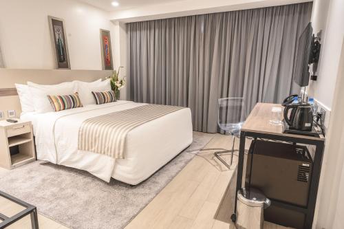 a hotel room with a bed and a television at Sarova Imperial Hotel in Kisumu
