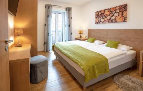 a bedroom with a large bed with a green blanket at Ferienwohnungen Kiesenberg in Thanstein