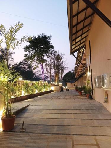 a walkway with potted plants on the side of a building at Aananda Wellness and Resorts in Dharmastala