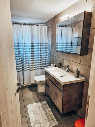 a bathroom with a sink and a toilet and a mirror at Cozy Home in Klitoria