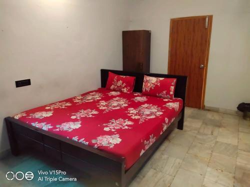 a bedroom with a bed with a red bedspread at Le Grace Eden in Madurai