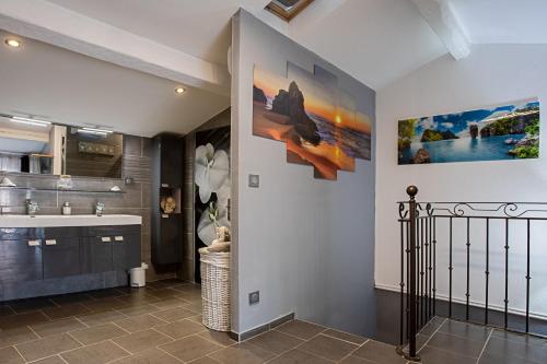 - un couloir avec une salle de bains pourvue d'un lavabo et d'un miroir dans l'établissement Maison de village Carcès, à Carcès