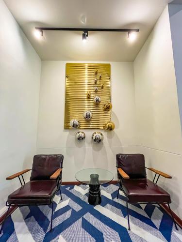 a room with two chairs and a glass table at SureStay by Best Western Iconic Ari-Jatujak in Bangkok