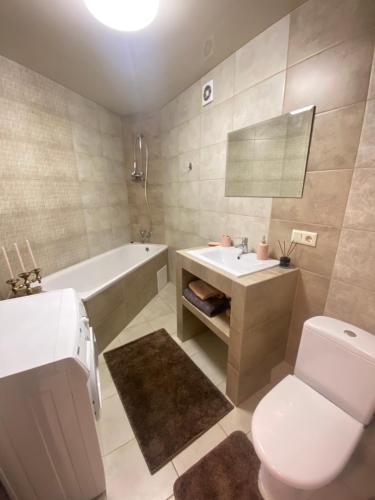 a bathroom with a toilet and a tub and a sink at Центр (6). Поруч Став та Парк in Ternopilʼ