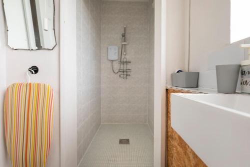 a bathroom with a shower with a striped towel at Bethel Nook, a cosy stay in the Welsh Valleys in Hirwaun