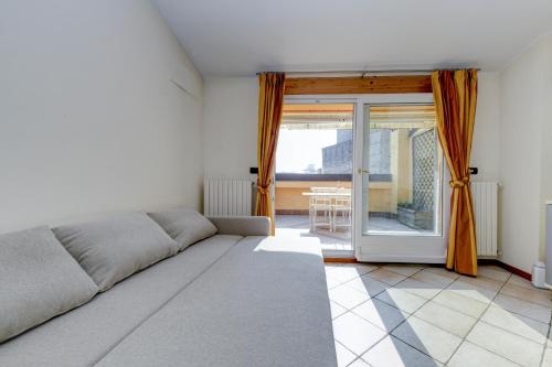 - une chambre avec un lit et une porte coulissante en verre dans l'établissement Sunset Apartment Home & Terrace, à Sirmione