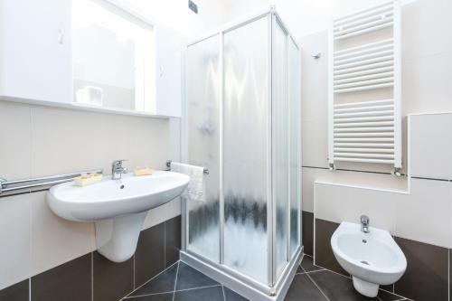 La salle de bains est pourvue d'un lavabo, d'une douche et de toilettes. dans l'établissement Sunset Apartment Home & Terrace, à Sirmione