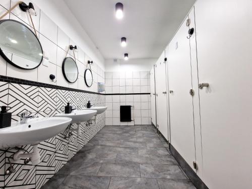 a bathroom with two sinks and two mirrors at Hostel Helvetia - PRIVATE ROOMS in CITY CENTER and OLD TOWN in Warsaw