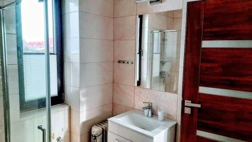 a bathroom with a sink and a red door at Domek u Zbyszka in Groń