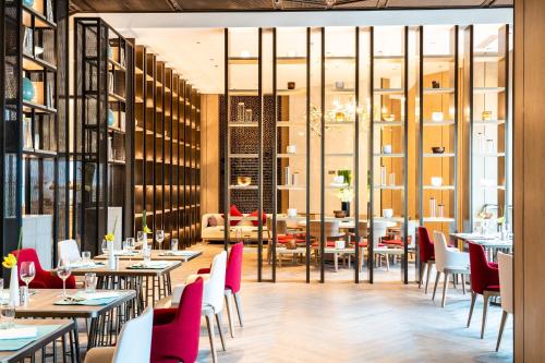 a dining room with tables and chairs and windows at Conrad Shanghai in Shanghai