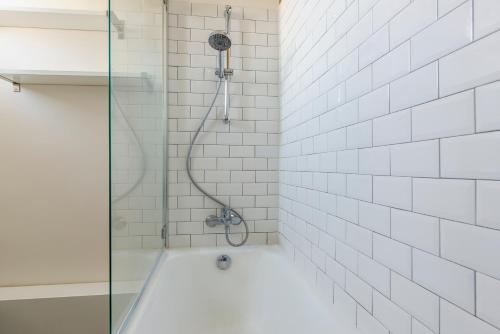 La salle de bains est pourvue d'une douche avec une porte en verre. dans l'établissement Courcelles Design Duplex, à Paris