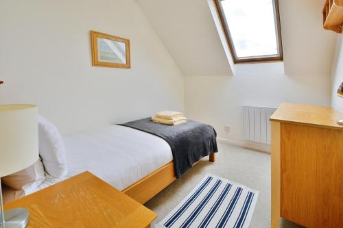 a bedroom with a bed with a blue towel on it at Nyhavn Lakeside Cottage in Cirencester