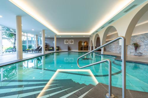 a swimming pool in a hotel with blue tiles at Hotel Garni Katnau in Schenna
