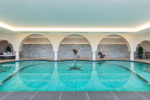 a large indoor swimming pool in a building at Hotel Garni Katnau in Schenna