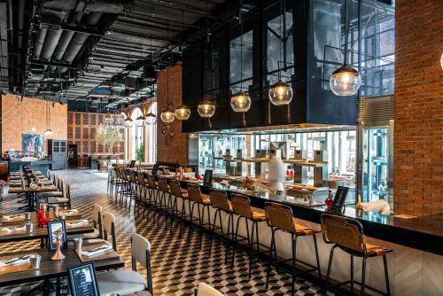 a restaurant with a long bar with chairs and tables at Conrad Shanghai in Shanghai