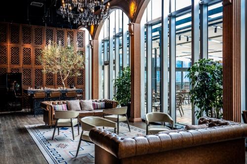 a lobby with leather couches and tables and windows at Conrad Shanghai in Shanghai
