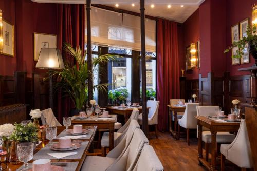 - un restaurant avec des tables et des chaises dans une salle aux murs rouges dans l'établissement Hotel De Seine, à Paris
