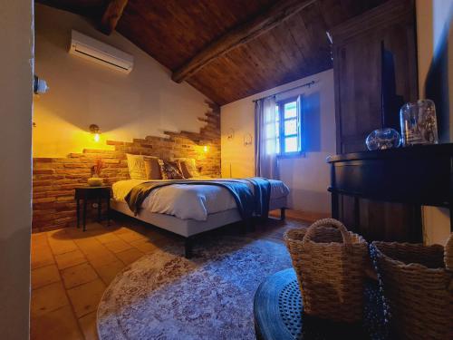1 dormitorio con cama y pared de piedra en CASEDDU A LECCIA vue mer et piscine, en Viggianello