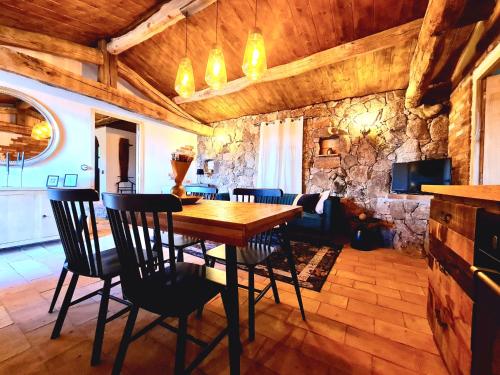 un salon avec une table et des chaises en bois dans l'établissement CASEDDU A LECCIA vue mer et piscine, à Viggianello