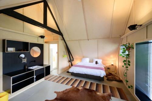 a bedroom with a bed and a sink in a room at Het Lage Noorden in Marrum