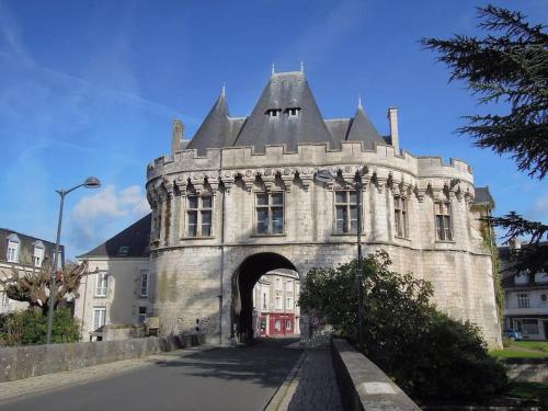 a stone building with an archway in a street at Gite troglodyte Les Iris in Villiers-sur-Loir