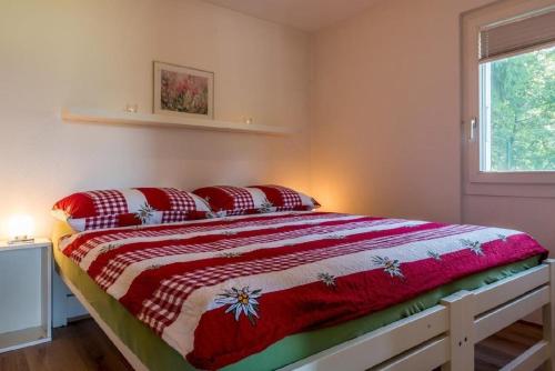 a bedroom with a bed with red pillows on it at Chalet Lara in Fiesch