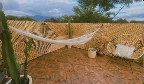 a hammock on a wooden fence with a cactus at Casa Amapolas Oaxaca in Oaxaca City